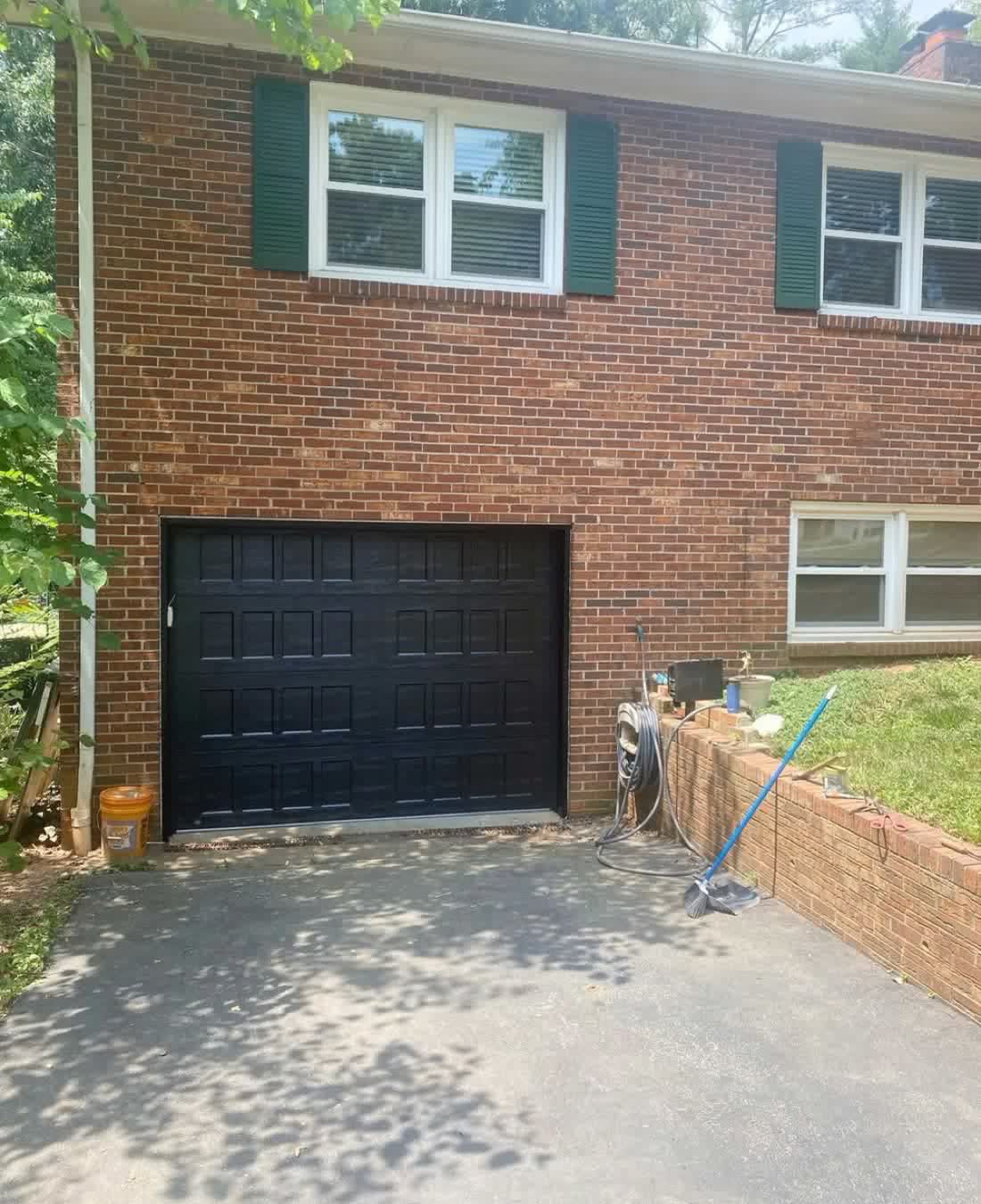 Custom black garage doors installed on a brick home